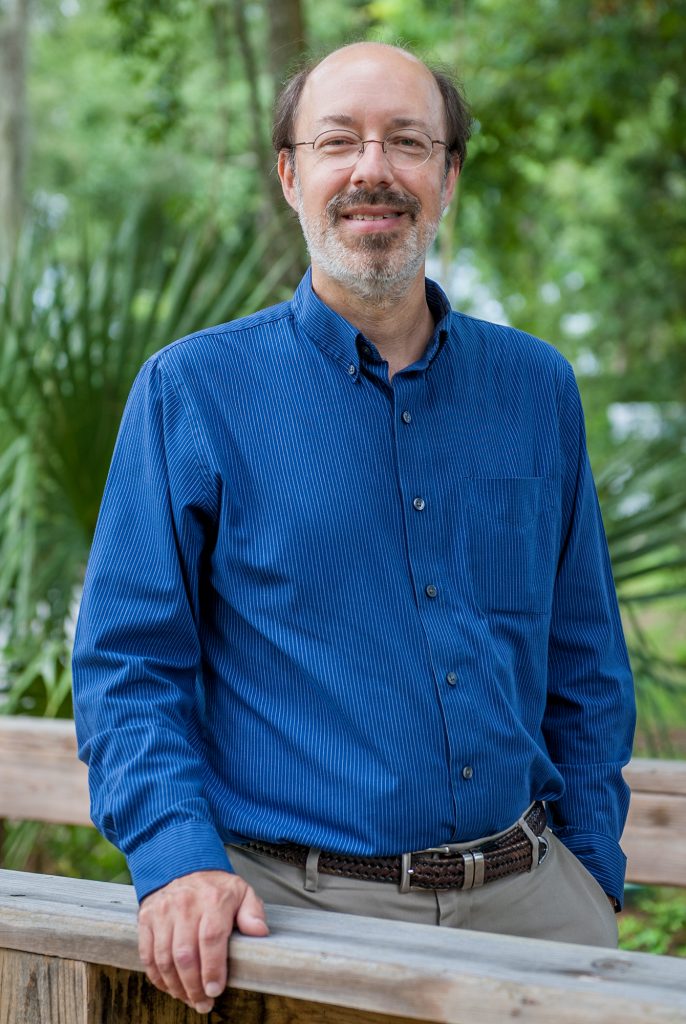 Portrait of Jaret Daniels standing in the Butterfly Rainforest exhibit