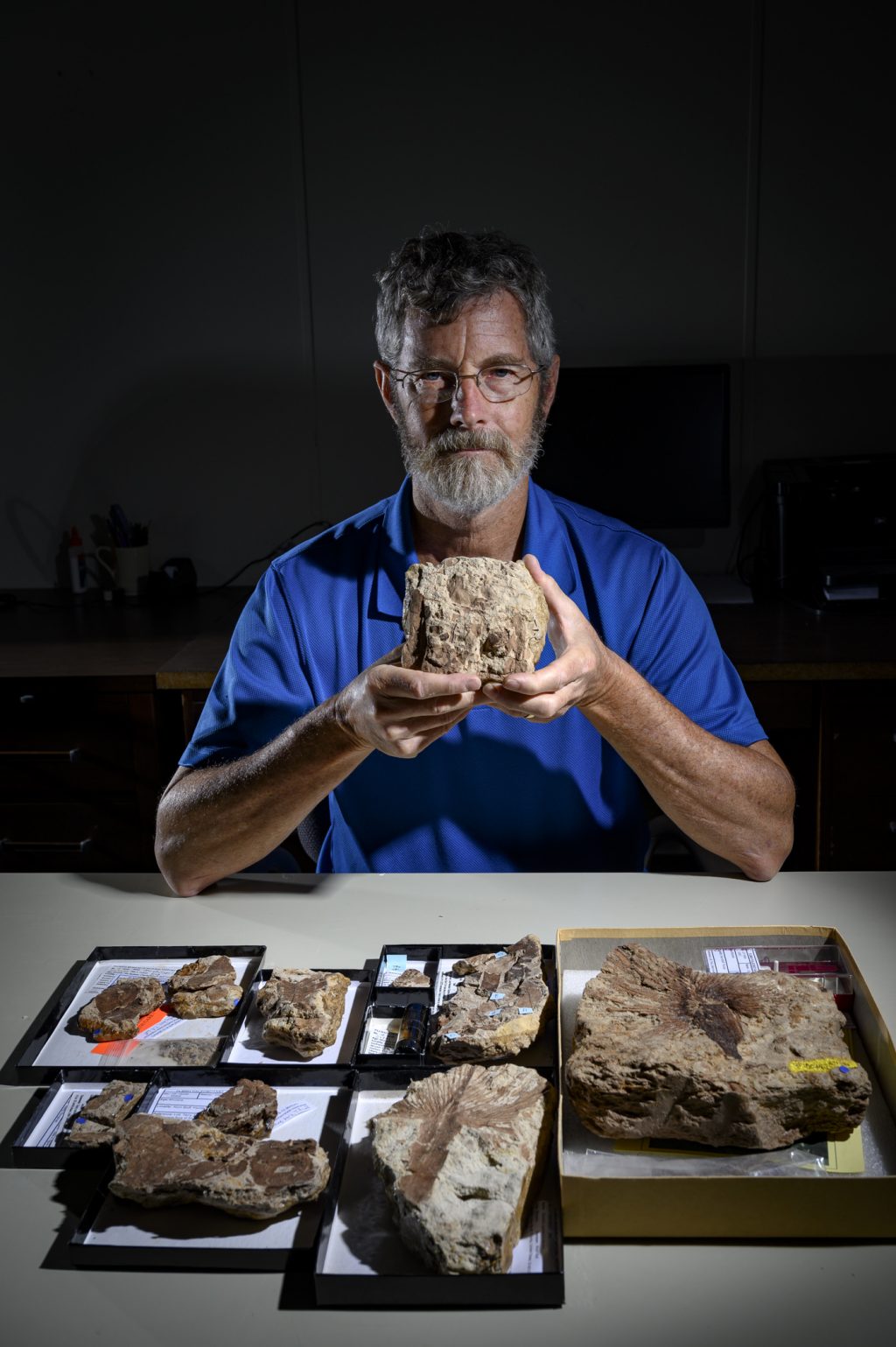A scientist holding a fossil