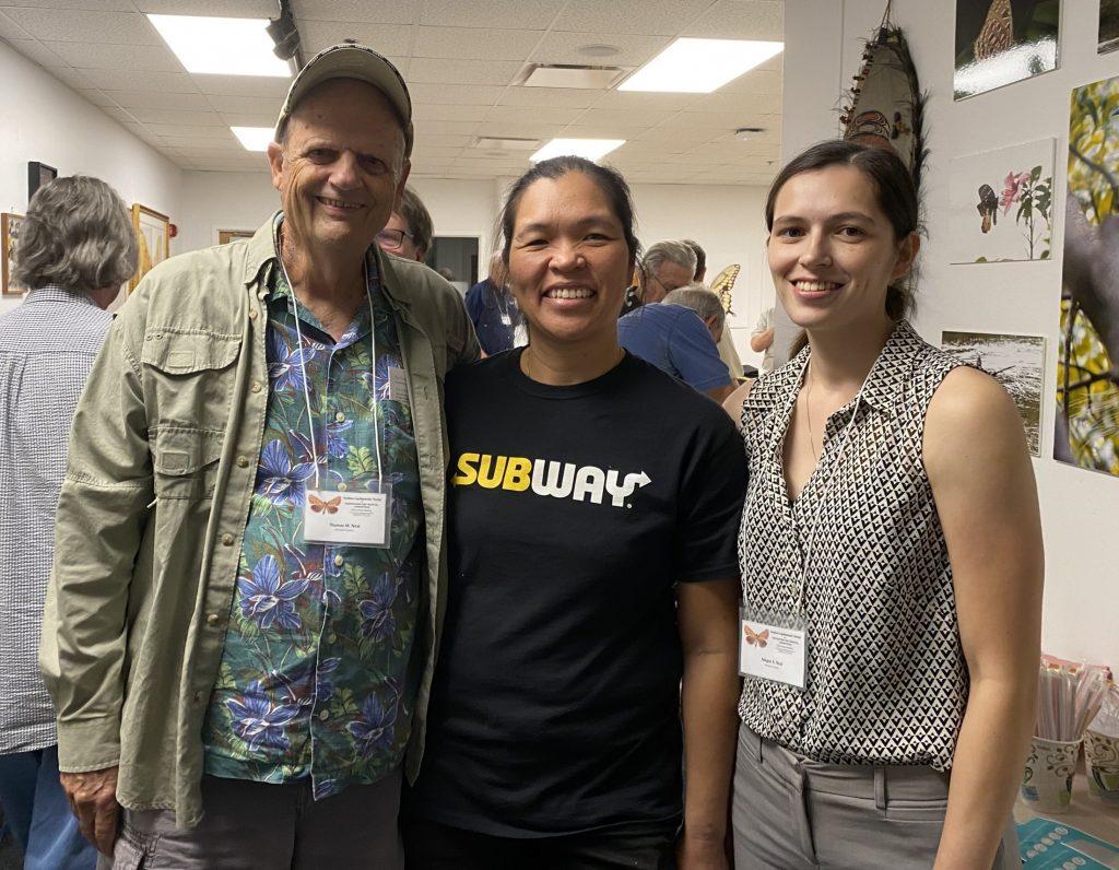 A man and two women standing together in the McGuire Center conference room.