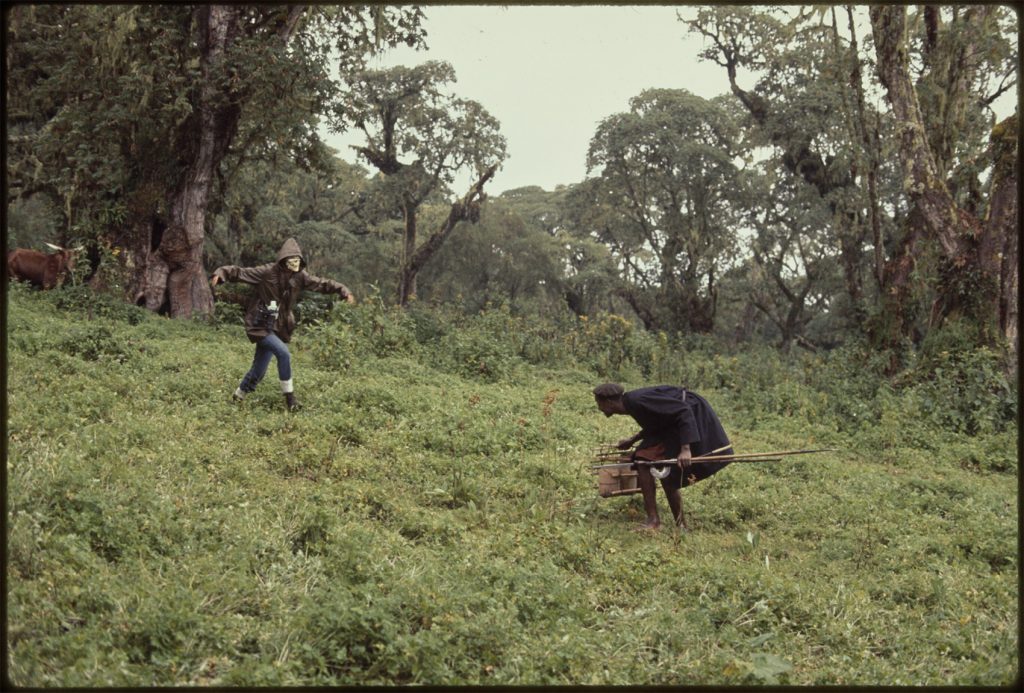 woman with skull mask and arms outstretched approaches man